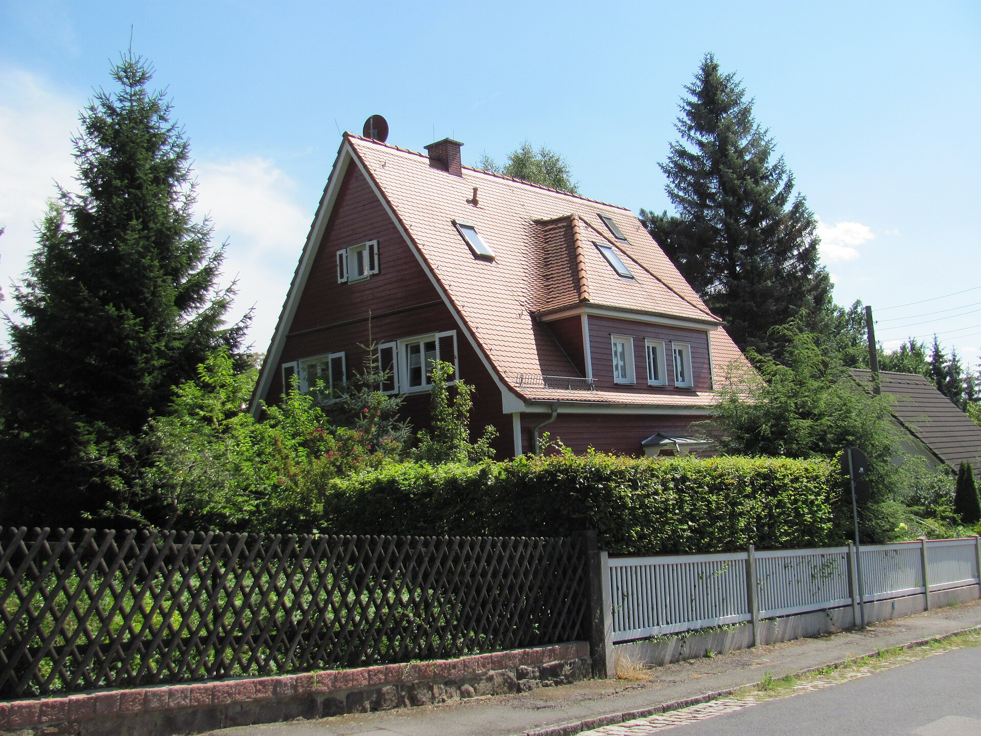 Freistehendes Wohnhaus mit steilem Satteldach, Gaube und Holzverschalung